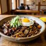Bol de Jajangmyeon traditionnel avec nouilles, sauce au soja noir, concombre et œuf coulant